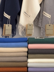 Close-up of assorted cashmere scarves in multiple colors with elegant tassel details