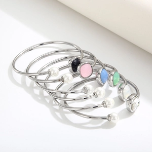 Macro shot of silver titanium steel open bracelets with colorful square zircons and pearls