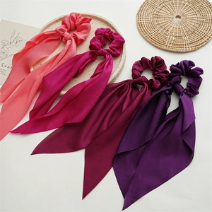 Detail of colorful satin scrunchies with long ribbons in purple, red, and pink colors