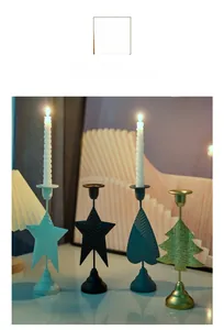 Detail of four geometric metal candle holders in star, heart, and tree shapes