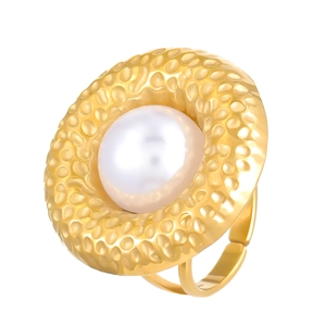 Detail of a large white pearl on a gold hammered metal ring with open band design