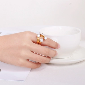 Close-up of a 18K gold-plated open ring with four white crystals on a hand