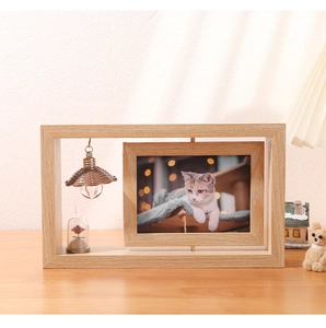Close-up of a rotating wooden double-sided photo frame with decorative miniature lamp