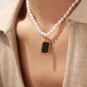 French style pearl necklace with black rectangular pendant and crystals on a model