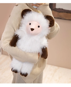 Detail of soft white plush sheep toy with brown horns being held in a warm cozy setting