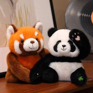 Cute plush red panda and giant panda dolls with soft faux fur on a wooden table