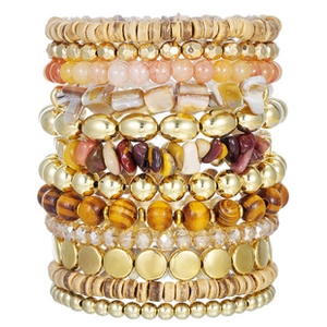 Dettaglio del set di bracciali bohémien multistrato con perle dorate e in legno