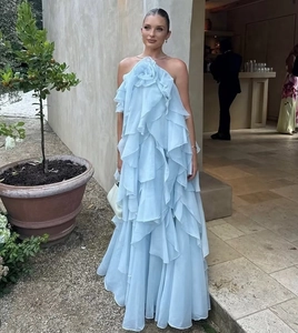 Detail of light blue halter neck dress with large floral ornament and layered skirt