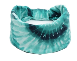 Vue détaillée du tissu tie-dye vert et du design large élastique du bandeau de sport