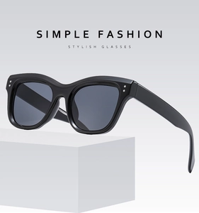 Detail of square black sunglasses featuring stylish metal rivet accents on the frame