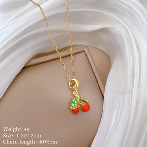 Vue macro d'un collier cerise doré avec fruits rouges et feuilles sur soie