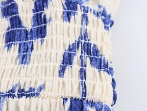Detailed macro view of elastic blue and white smocking texture on long sleeve dress