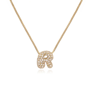 Detail of bubble letter R pendant with cubic zirconia on a golden box chain necklace
