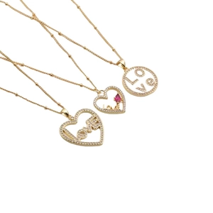 Trois colliers cœur dorés avec pendentif LOVE et zircons sur fond blanc épuré