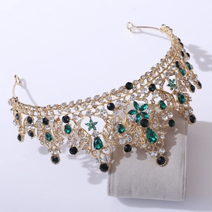 Luxury gold bridal tiara with green and black crystals on grey velvet pillow