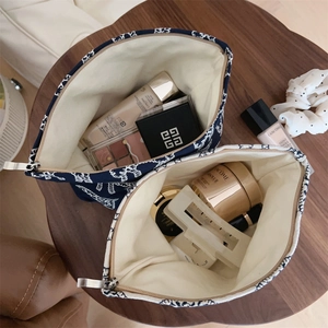 Macro view of canvas makeup bags with wave patterns and silver zipper showing large capacity