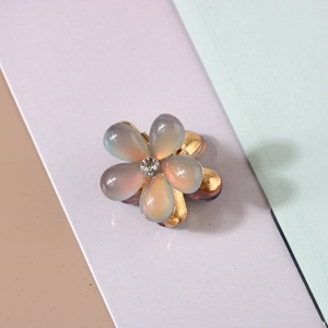 Close-up of a resin flower hair claw with frosted petals and a sparkling center rhinestone
