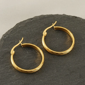 Minimalist 18k gold plated stainless steel hoop earrings with textured edge on slate