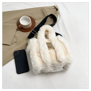 Close-up of fluffy cream white plush tote bag featuring Have A Nice Day leather patch