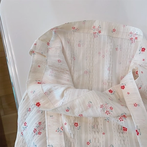 Close-up of white floral cotton fabric with vertical hollow lace texture and pink flower print