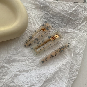 Detail view of 3-piece floral resin hair clips set with gold metal alligator base