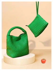 Detail of green woven tote bag set with matching pouch and texture on a minimalist stand