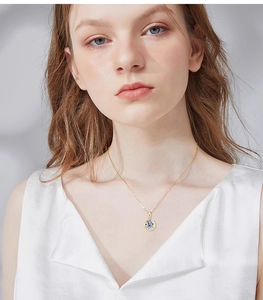 Close-up of elegant gold S925 silver necklace with round moissanite pendant on a model