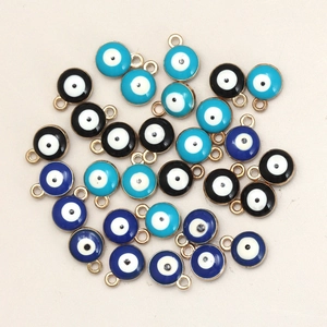 Macro shot of 8mm double-sided enamel evil eye charms in blue and black for DIY jewelry