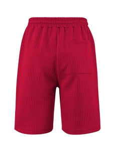 Detail of red waffle textured casual shorts showing elastic waistband and fabric weave