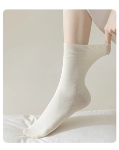 Detailed shot of comfortable beige cotton crew socks, showing stretchy ribbed cuff.