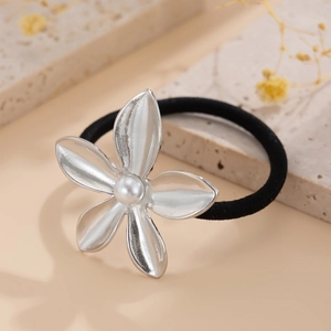 Detail of silver five-petal flower hair tie with brushed metal finish and pearl center