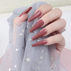 Glossy rose pink ballerina long press-on nails shown on hand with elegant tulle backdrop