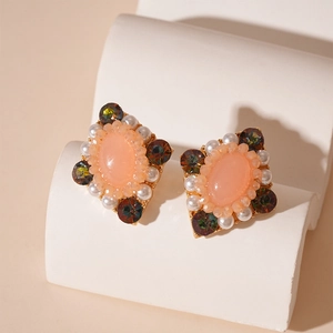Details von Vintage-Ohrsteckern mit rosa Harz und Perlenbesatz im Palaststil
