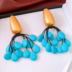 Detail of vintage bohemian teardrop earrings with turquoise stones in a jewelry box