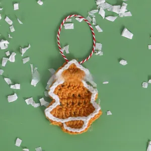 Detail of handmade crochet Christmas tree ornament with yellow yarn and white scalloped edges