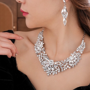 Detailed view of a silver floral jewelry set with sparkling crystals on a female model