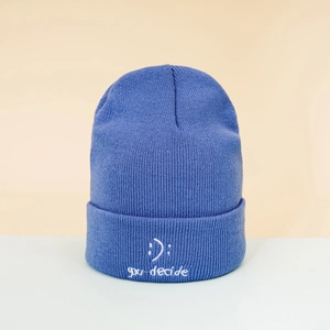 Detail of navy blue beanie featuring white you decide text and smiley face embroidery