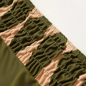 Detail of smocking texture and dark green with pink diagonal stripes on swimwear