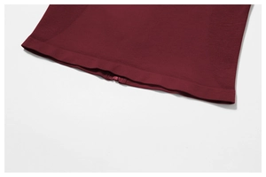 Detail of burgundy sports top featuring elastic ribbed fabric and adjustable hook eye closures