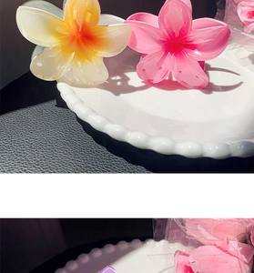Detailed close-up of three gradient resin floral hair claws in yellow, pink and purple
