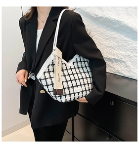 Detail of black and white checkered tote bag featuring woven texture and branded ribbon