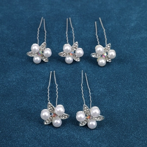 Macro shot of silver U-shaped hairpins with pearls and sparkling crystal flowers