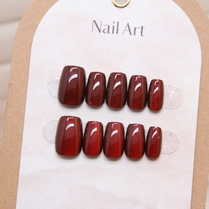 Glossy deep red cat eye press-on nails in short square shape shown on display card
