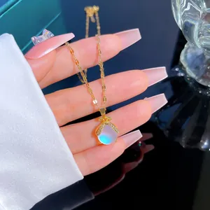 Detail of gold lucky pouch pendant necklace with iridescent gemstone and zircon inlay