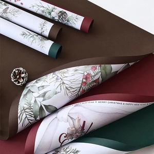 Matte Christmas wrapping paper with festive pine cones and holiday greenery patterns
