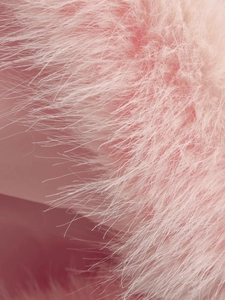 Vue macro montrant la texture douce et le tissu en fausse fourrure rose du manteau