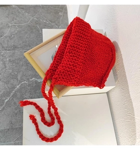 Détail du bonnet à oreillettes en grosse maille rouge avec lanières tressées