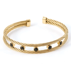 Detail of twisted cable gold bracelet featuring five circular black zircon gemstones
