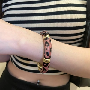 Vue détaillée du bracelet en acrylique léopard rose avec connecteurs en métal doré