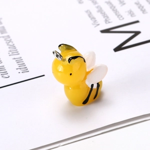 Detailed macro view of a yellow resin bee pendant with wings for DIY jewelry